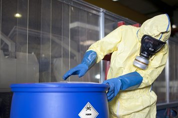 hazard class 6 poison material in drum handled by employee in PPE